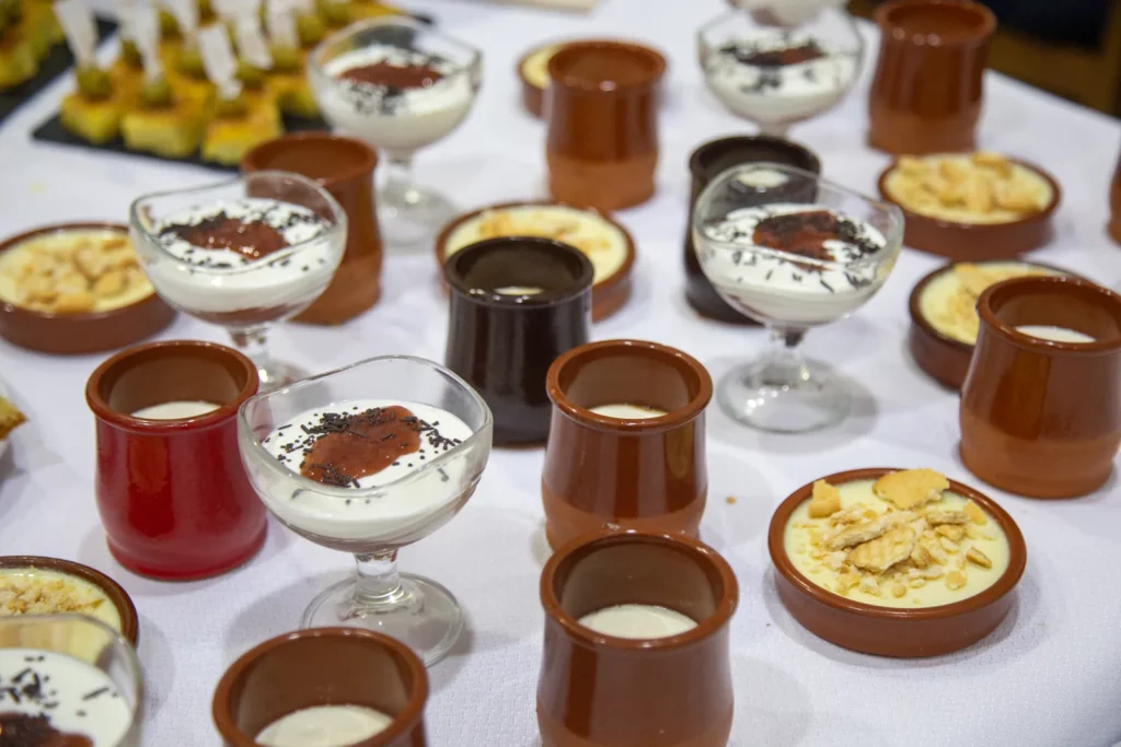 Postres variats servits en terrissa i copes de vidre en un bufet.
