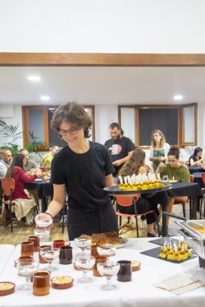 Cambrera servint postres i aperitius en una safata.