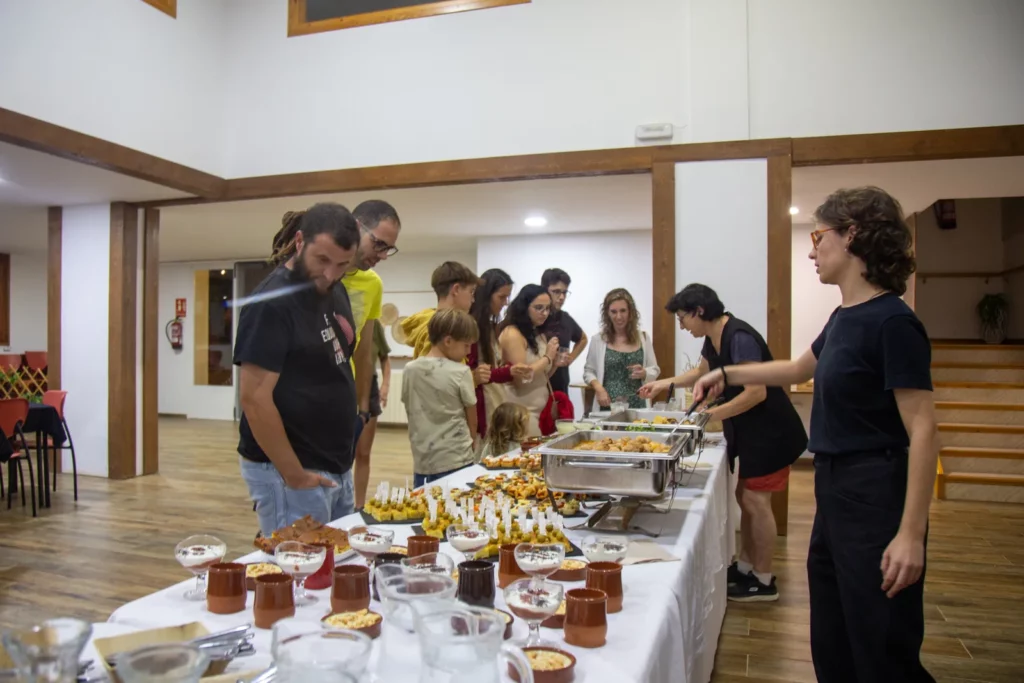 Servei de bufet amb plats i postres, amb persones servint-se.
